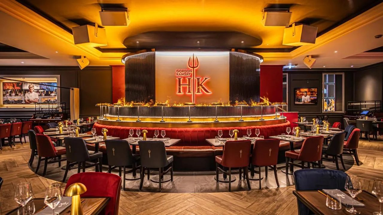 A restaurant with tables and chairs and a bar at The Cumberland on Great Cumberland Place, Marble Arch