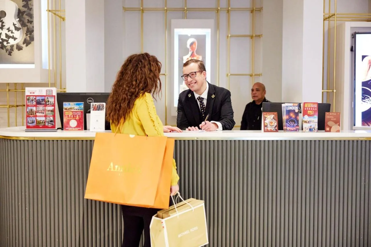 A guest with a shopping bag standing at the reception counter
